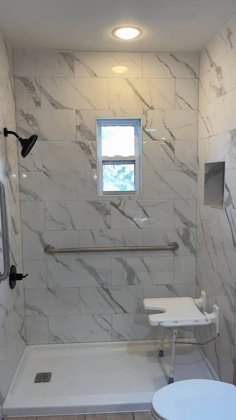 ADA accessible marble shower with grab bar and shower seat in Corpus Christi