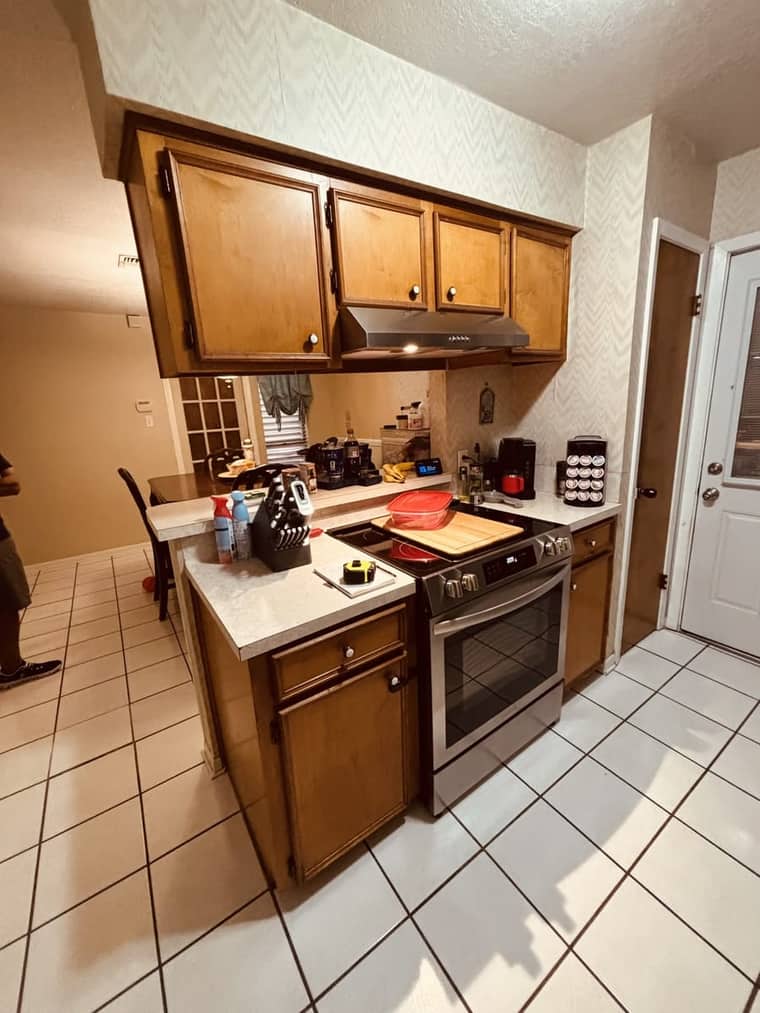 Dated kitchen range wall with old wood cabinets before remodeling