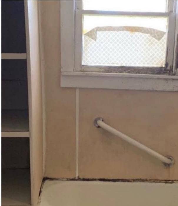 Worn tub surround with aging walls before bathroom remodeling in Corpus Christi