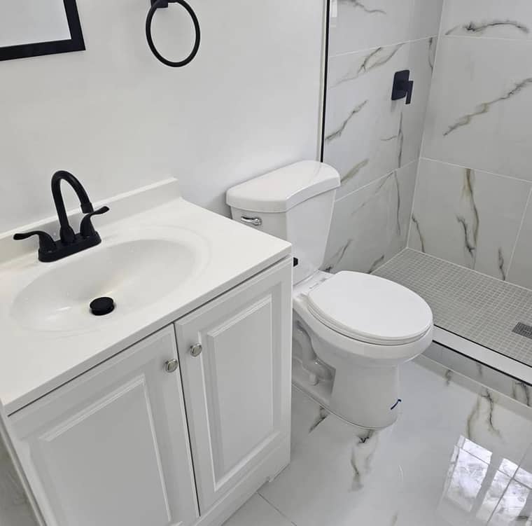 Modern bathroom with black fixtures and marble tile in Corpus Christi