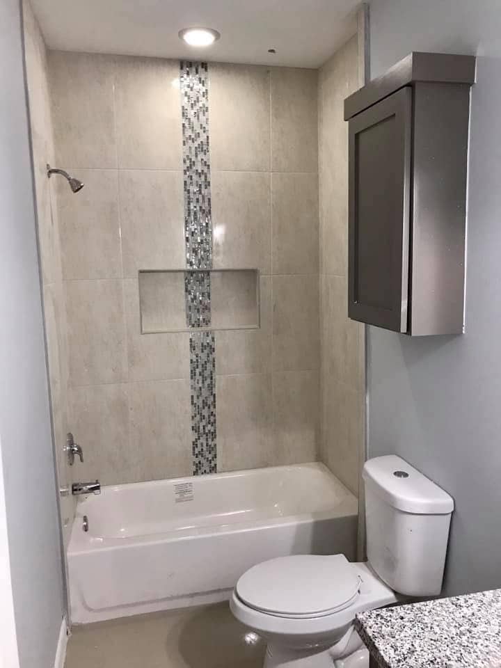 Bathtub surround with mosaic tile accent strip in Corpus Christi