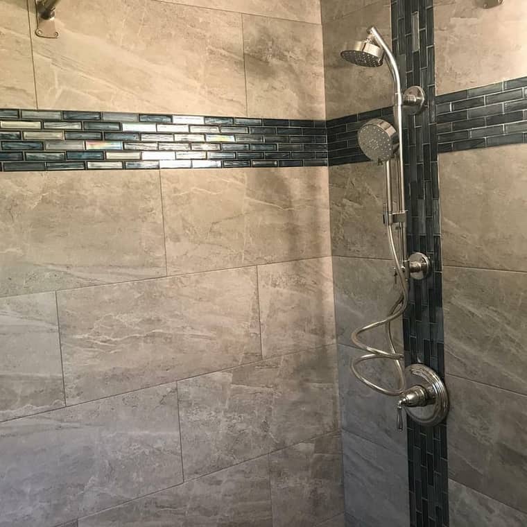 Walk-in shower with glass mosaic accent strip and dual shower heads in Corpus Christi