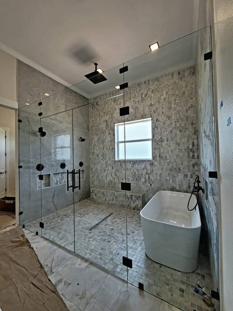 Luxury glass-enclosed shower with freestanding tub and mosaic tile in Corpus Christi