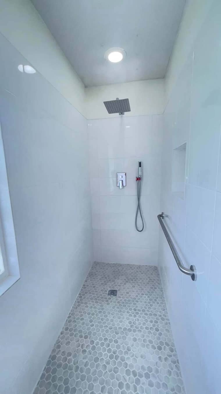 Modern walk-in shower with hexagon floor tile and rain head in Corpus Christi