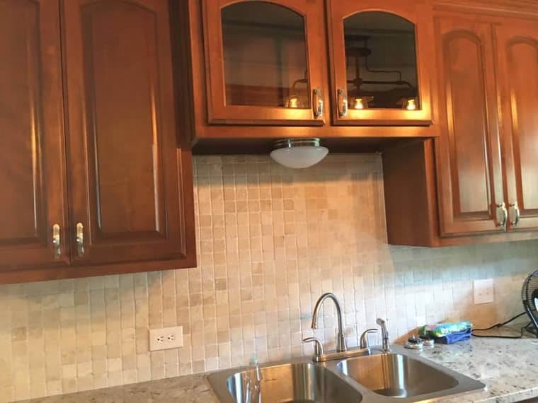 Custom wood cabinets with glass fronts and tile backsplash in Corpus Christi