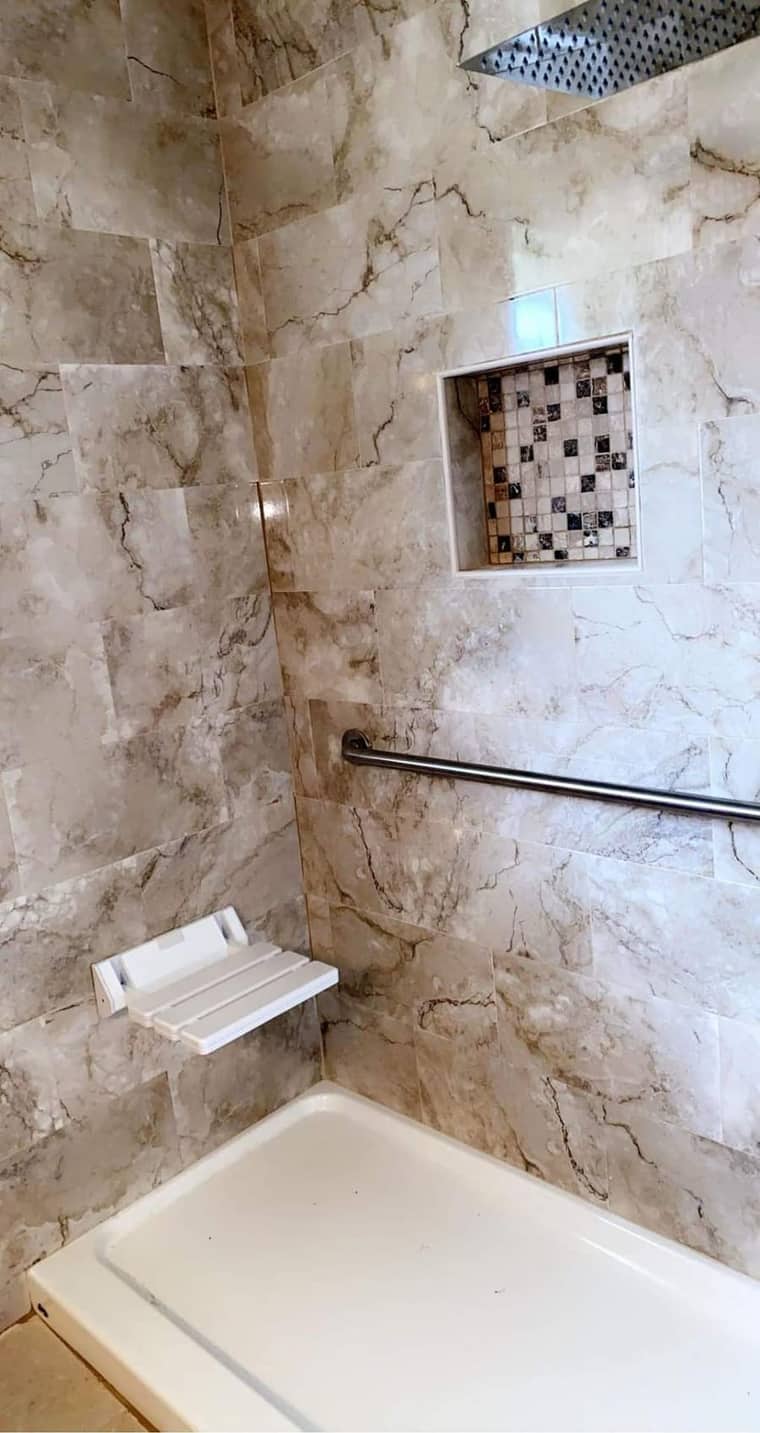 Marble tub surround with mosaic niche and grab bar in Corpus Christi