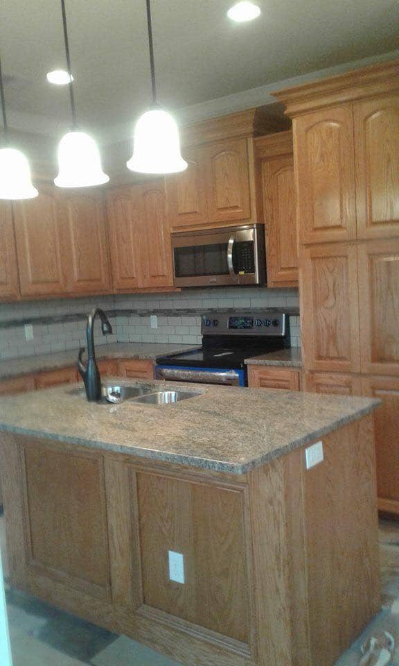 Oak cabinet kitchen with granite island and pendant lights in Corpus Christi