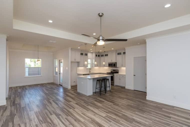 Open concept kitchen with island and wood-look tile flooring in Corpus Christi