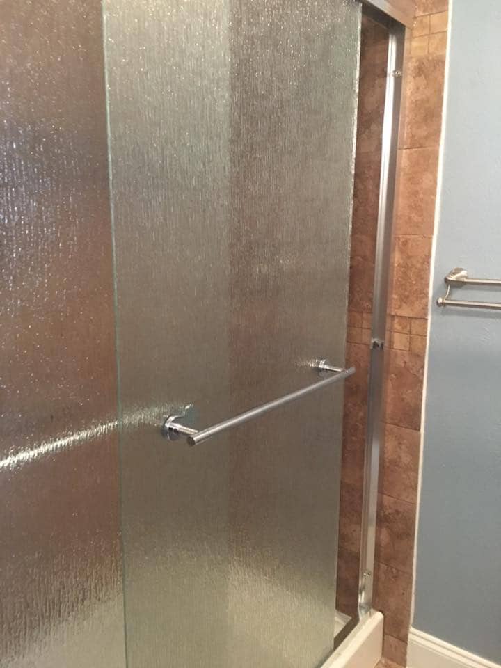 Rain glass shower door with travertine tile in Corpus Christi