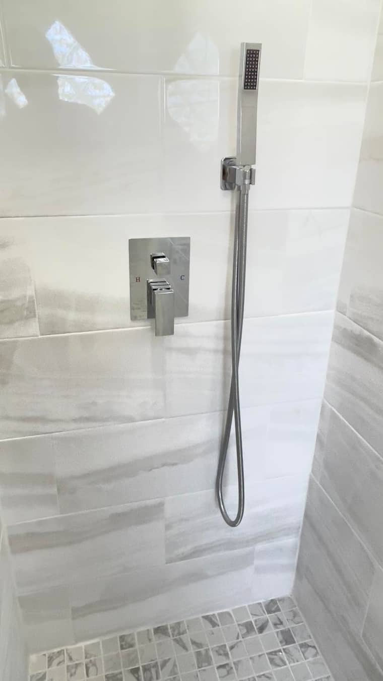 Chrome shower fixtures with marble tile wall installation in Corpus Christi