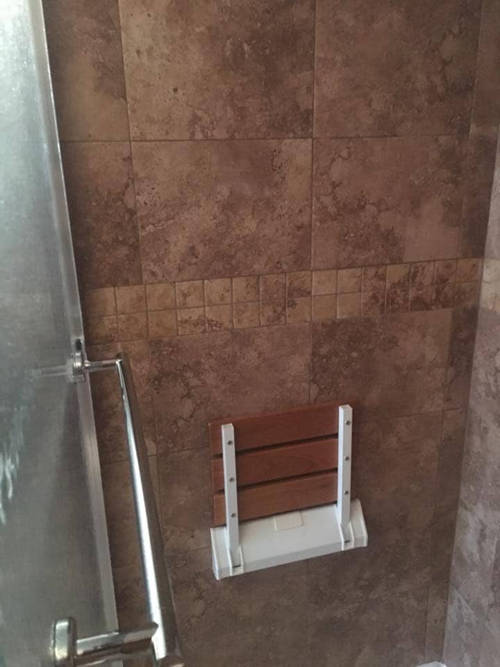 Wall-mounted teak shower seat with grab bar in Corpus Christi
