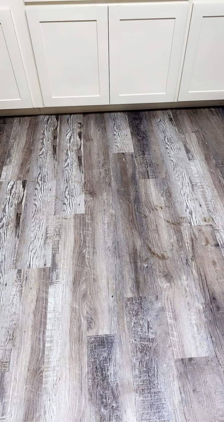 Gray rustic vinyl plank flooring with white cabinets in Corpus Christi