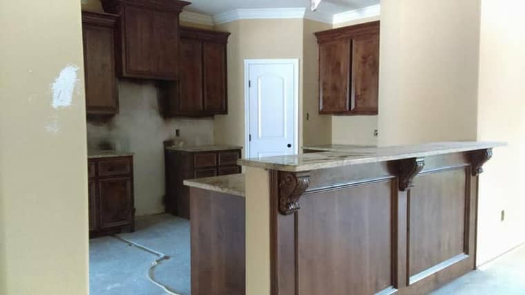 Custom walnut bar with carved corbels and granite countertop in Corpus Christi